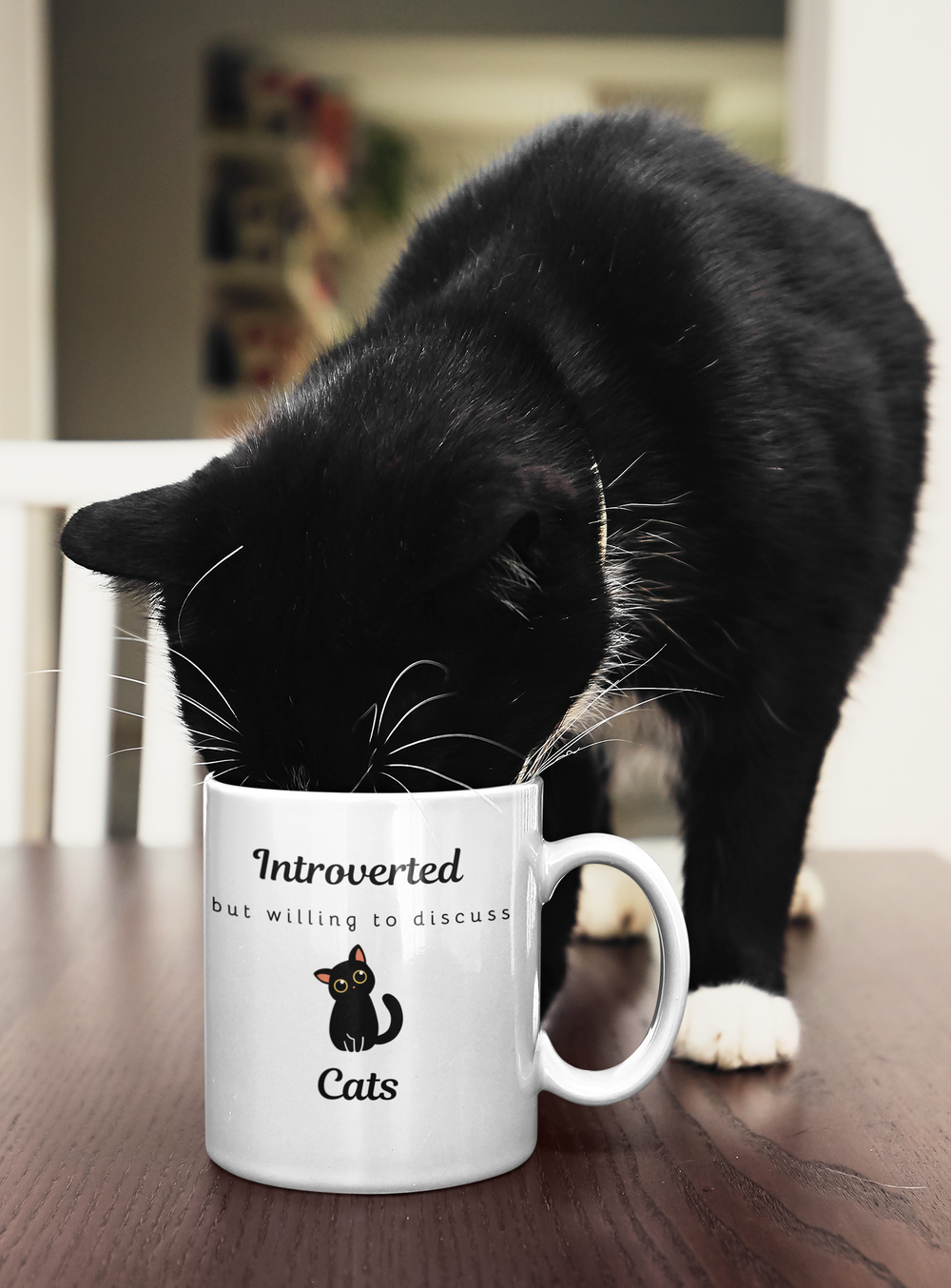 Black cat sipping from the Introverted But Willing To Discuss Cats mug